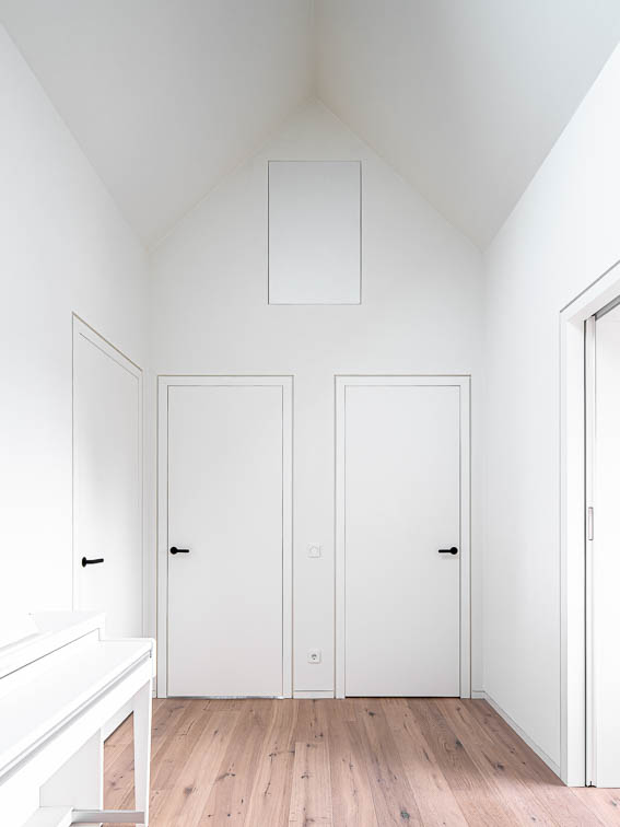 Innenraumperspektive des Flures im Dachgeschoss. Der Negativraum bildet ein Haus im Haus